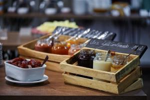 una mesa con 2 bandejas de madera de mermelada y mermeladas en Dall’Onder Grande Hotel Bento Gonçalves en Bento Gonçalves