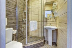 a bathroom with a shower and a sink and a toilet at Wellion Vodniy in Moscow