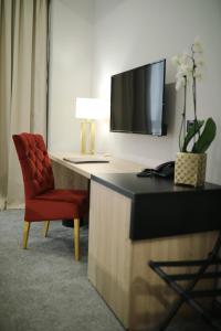 a living room with a tv and a chair at Teatro Verdi Boutique Hotel in Zadar
