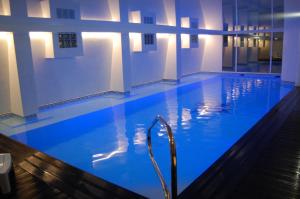 - une grande piscine d'eau bleue dans un bâtiment dans l'établissement Gran Carlina Hotel, à Le Mont-Dore