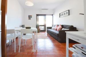 a living room with a couch and a table at Sesimbra 99 - T2 Apartment in Sesimbra