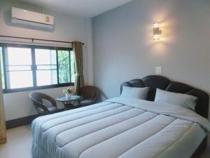 ein Schlafzimmer mit einem großen Bett und einem Fenster in der Unterkunft Big House Resort in Trat