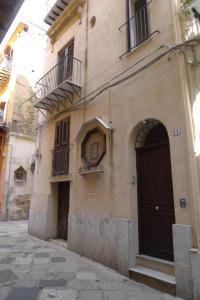 ein Gebäude mit einer schwarzen Tür und einem Balkon in der Unterkunft Casa Benzo in Palermo