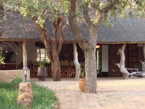 a group of trees in front of a building at Onduri Lodge in Outjo