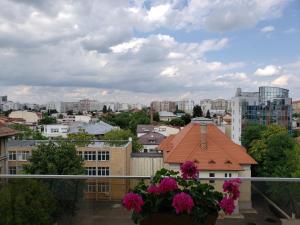 un balcón con flores y vistas a la ciudad en Urban Nest Apartment, en Bucarest
