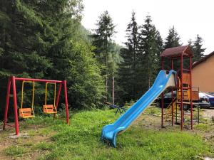 a playground with a blue slide and a gazebo at Cabana Cory Râușor in Râu de Mori