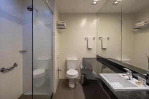 a bathroom with a toilet and a sink and a shower at Linx Galeão in Rio de Janeiro