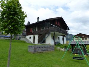 une maison avec une aire de jeux en face dans l'établissement Tgèsa Dutg Grond, à Sedrun