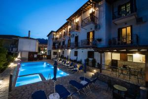a hotel with a swimming pool at night at Hotel Nostos in Nydri