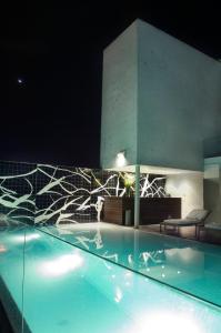 a swimming pool at night with a building at Habita, Mexico City, a Member of Design Hotels in Mexico City