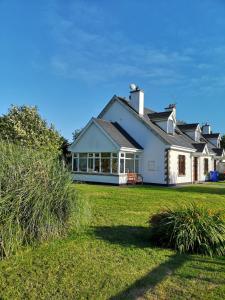 a white house with a large yard at Ban Milis 1 in Fethard on Sea