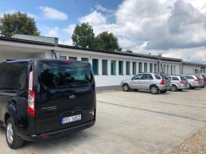 a black van parked in a parking lot at M&A GUEST ROOMS in Łomża