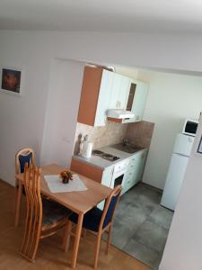 une petite cuisine avec une table en bois, une table et des chaises dans l'établissement Victoria Apartment, à Ljubljana
