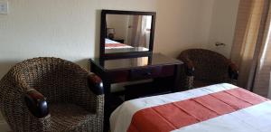 a bedroom with two chairs and a desk and a mirror at Ocean View Villas Unit G07 in Port Edward