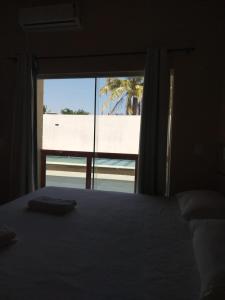 a bedroom with a bed and a view of a beach at Hotel Costa do Delta in Tutóia