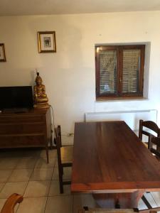 a dining room with a wooden table and a television at Via Osvaldo Moretti(complessoShalimar) in Ovindoli