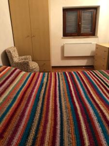 sypialnia z kolorowym kocem na łóżku w obiekcie Via Osvaldo Moretti(complessoShalimar) w mieście Ovindoli
