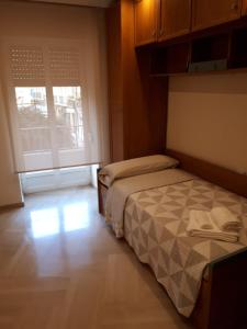 um pequeno quarto com uma cama e uma janela em Calle Periodista Pirula Arderius, 1 Primero em Alicante