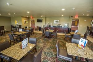 Cobblestone Inn & Suites-Winterset في Winterset: مطعم بطاولات وكراسي وبار