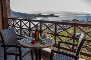 a table with two chairs and a bottle of wine on a balcony at Titagion Hotel in Plastiras