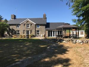 a large brick house with a gazebo at Aberystwyth, Pentre Farmhouse, in Capel Bangor