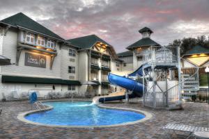 a pool with a slide in front of a hotel at Lodge at Five Oaks Pigeon Forge - Sevierville in Pigeon Forge