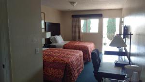 a hotel room with two beds and a window at Valley Hotel in Rosemead