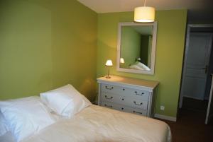 um quarto com uma cama e uma cómoda com um espelho em Château de Touvois em Maulévrier