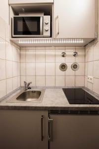 eine Küche mit einer Spüle und einer Mikrowelle in der Unterkunft Ferienwohnung Dennis in Lörrach