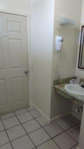 a bathroom with a sink and a phone on the wall at Valley Hotel in Rosemead