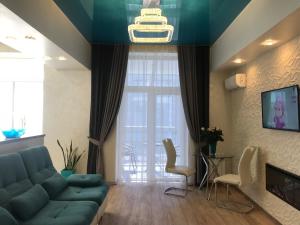 a living room with a blue couch and a large window at Luxury Apartment in Downtown, Near River Esplanade in Kharkiv