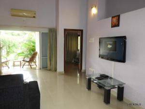 sala de estar con TV en la pared en J.RENTALS VILLA 33, en Anjuna