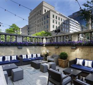 a patio with couches and tables and flowers at Hotel AKA Back Bay in Boston