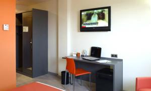 a room with a desk with a television on the wall at H2 Fuenlabrada in Fuenlabrada