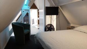 um quarto com uma cama, uma cadeira e uma escada em Résidence Surmont em Ieper