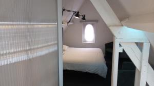 een kleine slaapkamer met een bed en een raam bij Résidence Surmont in Ieper