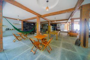 a room with a hammock and tables and chairs at Pousada São José in Barreirinhas