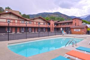 una piscina en un hotel con montañas en el fondo en Villa Motel at Manitou Springs, en Manitou Springs