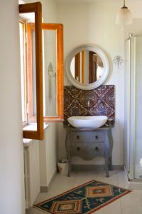 bagno con lavandino e specchio di Villa Cadenza a Murazzano