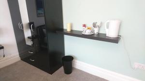 a black shelf on the wall in a room at Tippys Guesthouse in Newquay