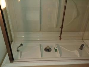 a bath tub with a shower and a sink at Bradford Vacation in Bradford