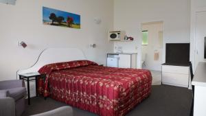 a hotel room with a bed and a television at Bk's Counties Motor Lodge in Pukekohe East
