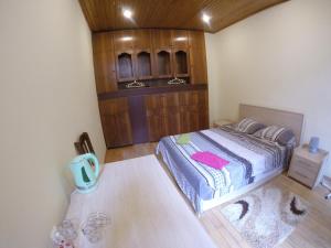Un dormitorio con una cama y un armario de madera. en "Green way" Guest house, en Tiflis