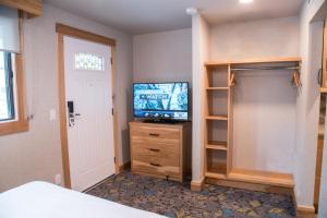 a bedroom with a tv and a closet at Tunnel Mountain Resort in Banff