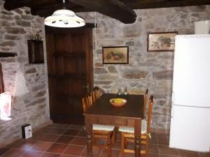a dining room with a table and a refrigerator at Casa Portela in Portela de Portomourisco
