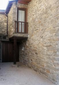 a brick building with a balcony on the side of it at Casa Portela in Portela de Portomourisco