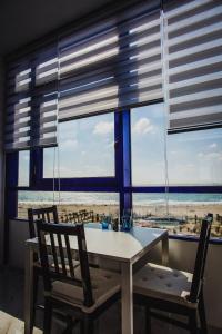 a table and chairs in a room with a view of the beach at Ashdod Beach Hotel in Ashdod