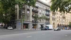 a street with cars parked in front of a building at Sweet Rooms Inn in Tbilisi City