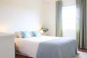a white bed with blue pillows in a bedroom at Casa da Altamora - up to 12 guests! in Cais do Galego