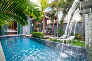 a swimming pool with a waterfall in a house at Two bedrooms pool villa at Saiyuan estate in Rawai Beach